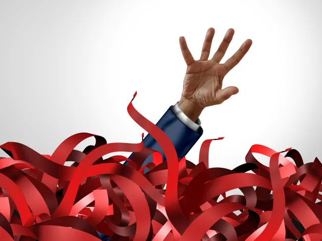 man in pile of red tape